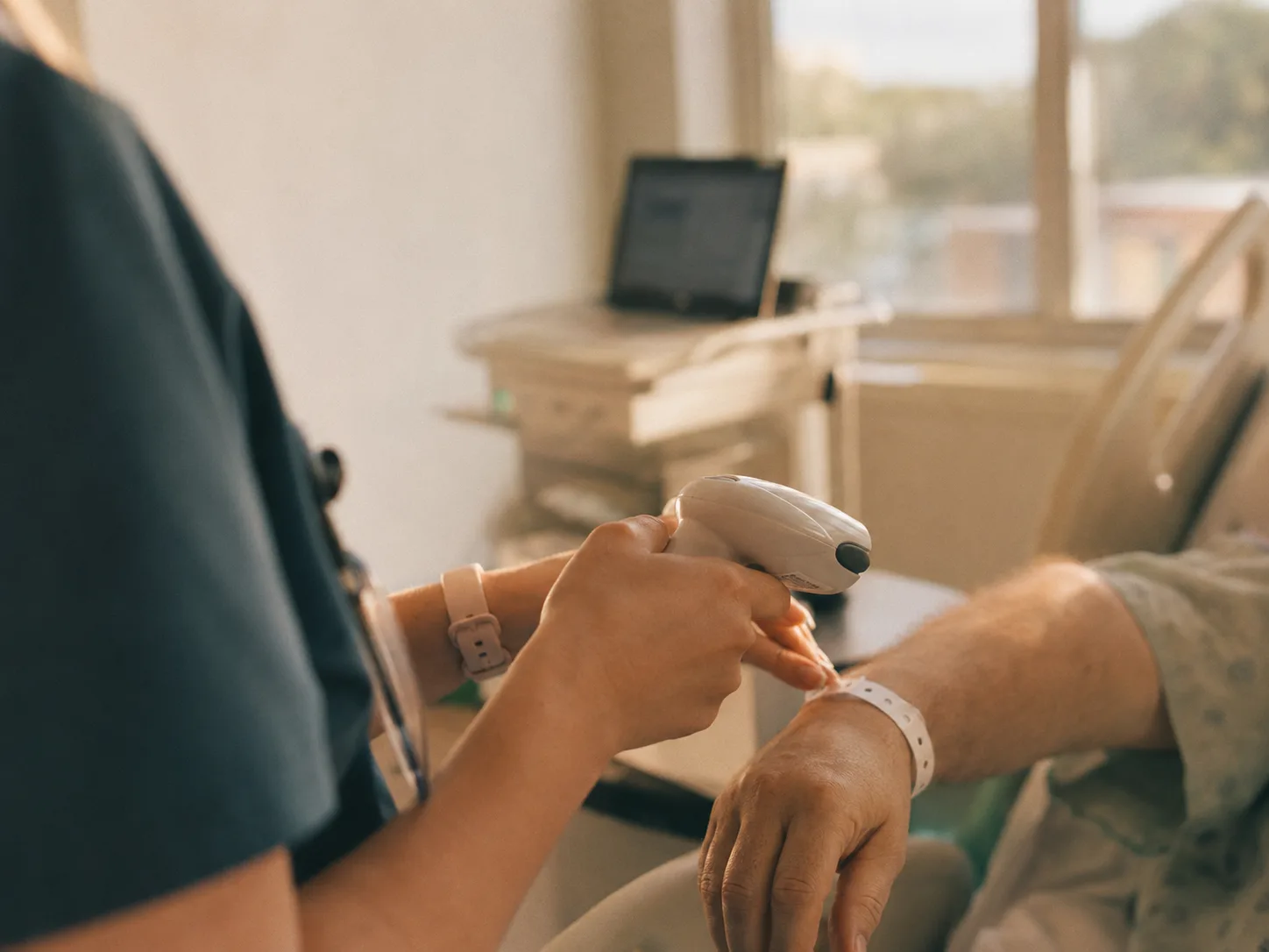A nurse scanning a hospital patient's wristband barcode at the bedside.